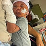 newborn, baby, infant, hospital, patient, beanie, gray_outfit, adult, parent, 抱抱, sleeping, awake, face, portrait, medical_equipment, monitoring, feeding_tube, blanket, indoors, caregiving