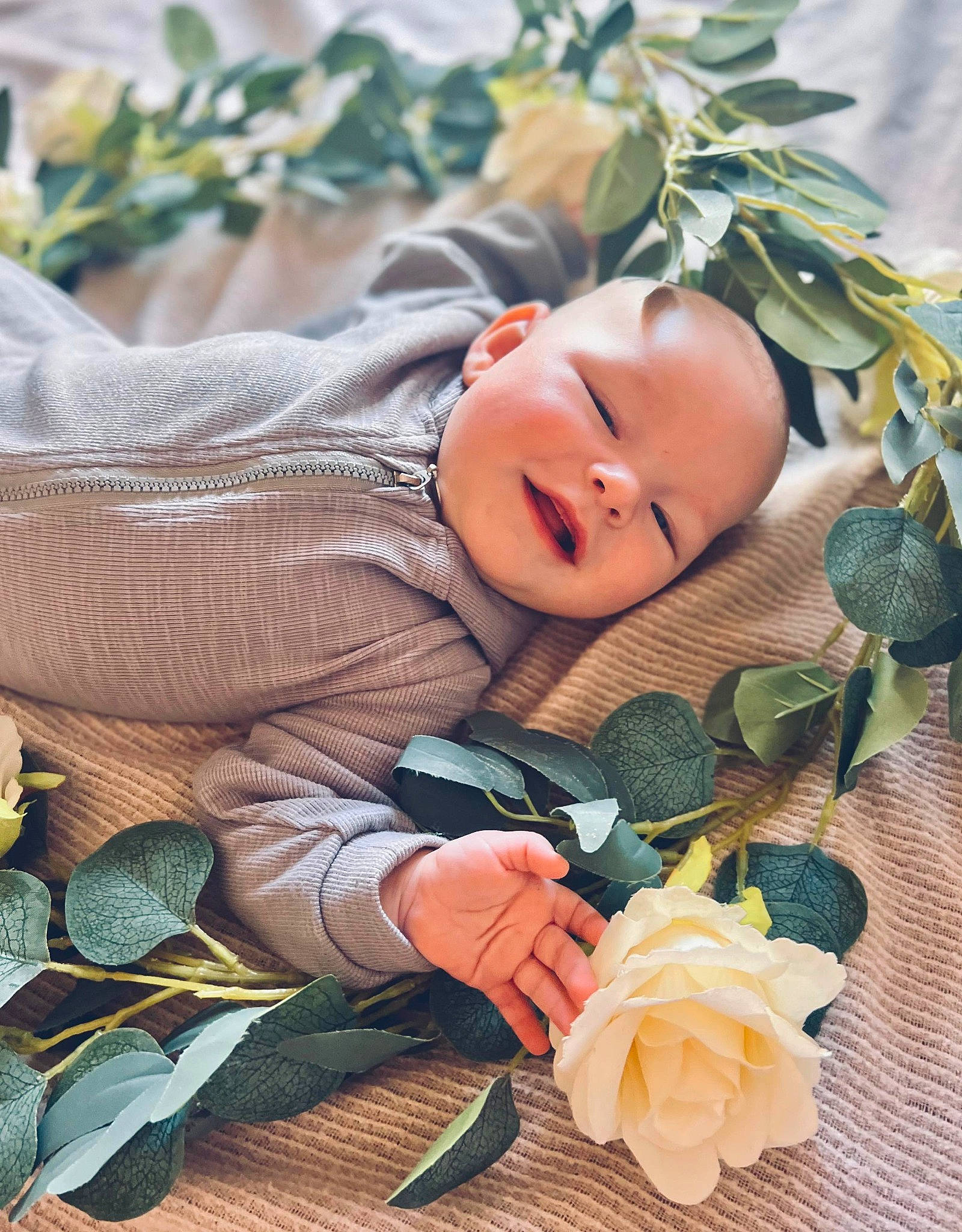 Joey is registered to the contest to win money with this photo: baby, baby_toddler_clothing, child, doll, flower, grass, hand, happy, headgear, people_in_nature, person, petal, plant, rose, rose_family, skin, smile, textile, toddler, tree