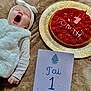 Arianna participe au concours pour gagner de l'argent avec cette photo : baby, infant, yawning, headband, white_clothing, blanket, cake, strawberry, golden_plate, milestone_card, hand, celebration, one_month, soft_texture, lying_down, cute, portrait, indoor, cozy, newborn