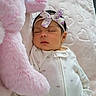 baby, newborn, sleeping, onesie, headband, floral, stuffed_animal, pink, bunny, blanket, heart_pattern, soft, cozy, indoor, child, peaceful, cute, infant, resting, portrait