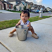 Ryu Nguyen joined the competition — help win amazing prizes! toddler, child, bucket, sidewalk, shoes, grass, suburban, houses, car, fire_hydrant, sky, clouds, curious, outdoor, daylight, concrete, casual, expression, street, residential_area