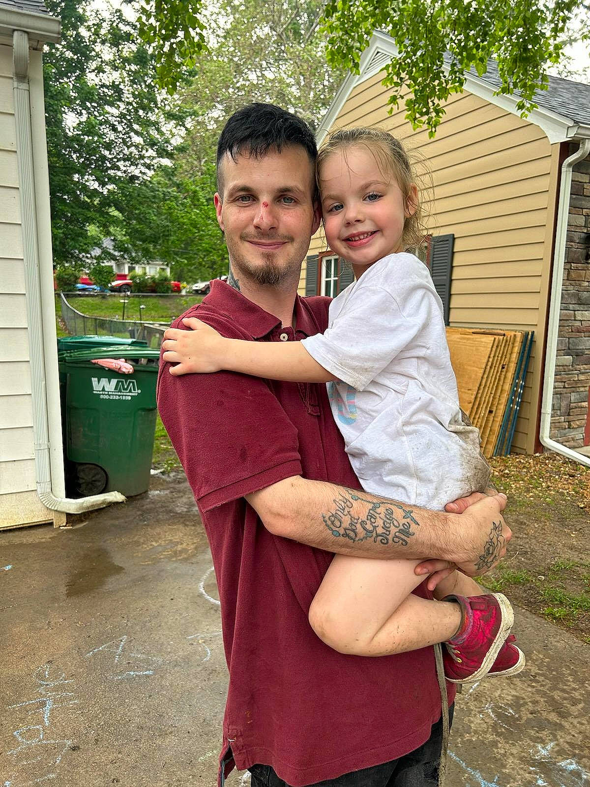 Maci is registered to the contest to win money with this photo: belt, child, door, event, face, fun, gesture, grass, happy, head, house, joy, leisure, person, plant, sitting, sleeve, smile, t_shirt, tree