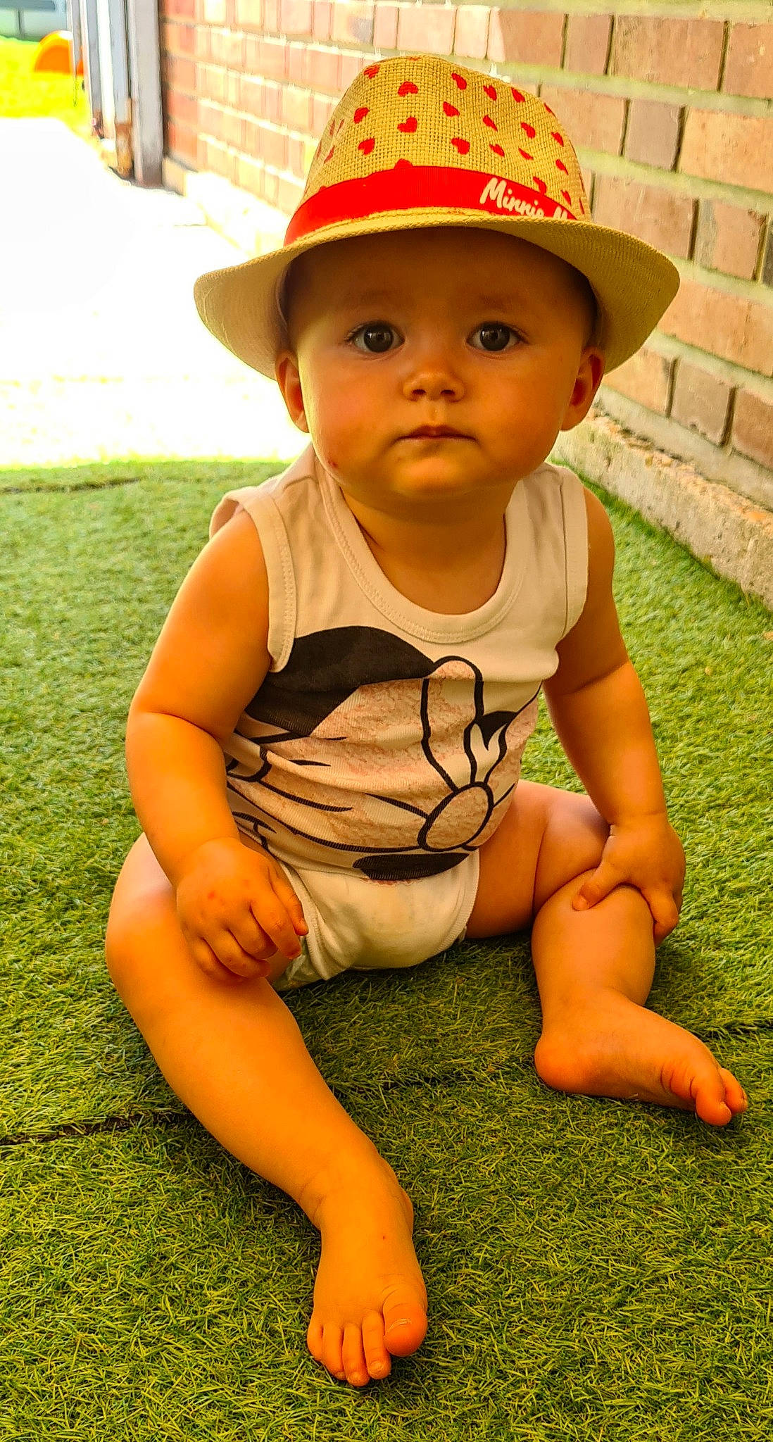 Inès participe au concours pour gagner de l'argent avec cette photo : baby_toddler_clothing, cap, eye, face, facial_expression, fun, grass, hairstyle, happy, hat, head, headwear, knee, leisure, person, skin, sleeve, summer, sun_hat, thigh