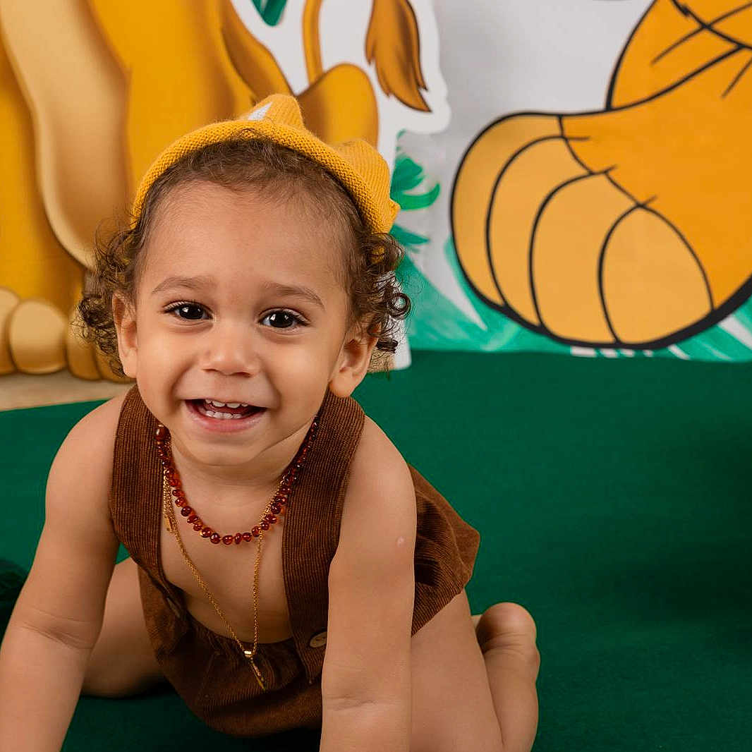 Zyane participe au concours pour gagner de l'argent avec cette photo : baby, balloons, beads_necklace, brown_clothing, child, crawling, curly_hair, cute, decorations, fun, green_carpet, happy, indoors, jungle_theme, person, playful, portrait, smiling, toddler, yellow_hat