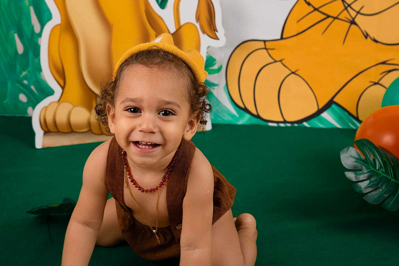 Zyane participe au concours pour gagner de l'argent avec cette photo : toddler, child, smiling, crawling, brown_clothing, yellow_hat, beads_necklace, green_carpet, balloons, jungle_theme, decorations, curly_hair, happy, playful, portrait, indoors, cute, baby, person, fun