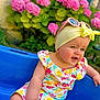baby, blue_chair, child, colorful_clothing, cute, flower, garden, green_leaf, happy, headband, nature, outdoor, person, pink_flower, portrait, smiling, summer, sunglasses, sunshine, toddler