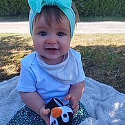 Ambre participe au concours pour gagner de l'argent avec cette photo : baby, blanket, bow, child, cute, grass, happy, headband, nature, outdoor, penguin, person, plush, portrait, skirt, smiling, socks, sunlight, toy, white_shirt