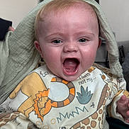 Finley joined the competition — help win amazing prizes! baby, child, infant, smiling, laughing, clothing, animal_print, toddler, indoors, blanket, face, happy, cute, expression, person, headwear, sitting, home, comfort, playful