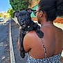 animal, back_view, black_dog, cute, daylight, dog, fence, leash, nature, outdoor, person, pet, puppy, sidewalk, street, summer_dress, sunglasses, tree, walking, woman