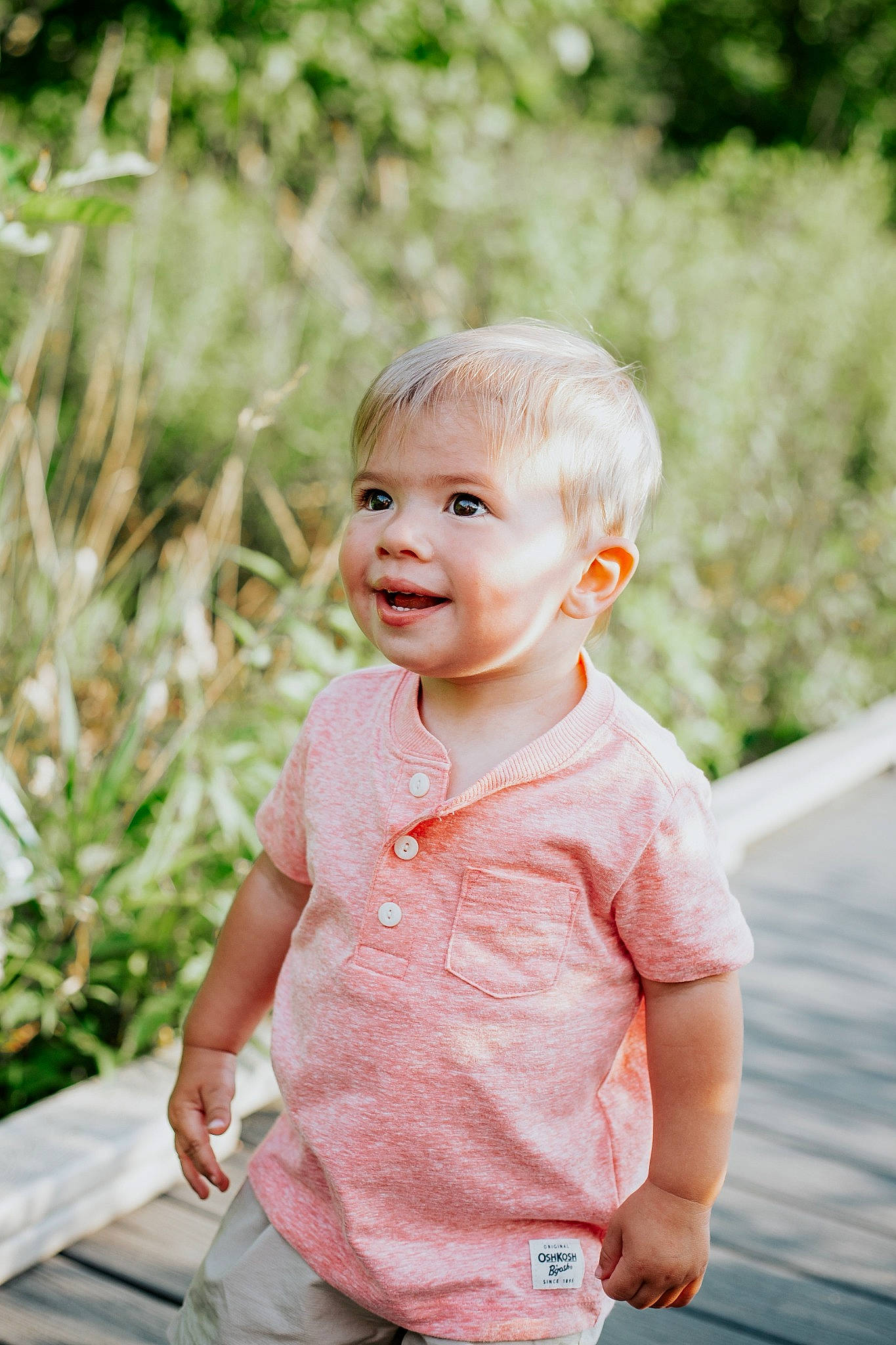 Krew is registered to the contest to win money with this photo: baby, baby_toddler_clothing, blond, child, fun, gesture, grass, happy, leisure, pattern, people_in_nature, person, plant, portrait_photography, sitting, sleeve, smile, t_shirt, toddler, tree
