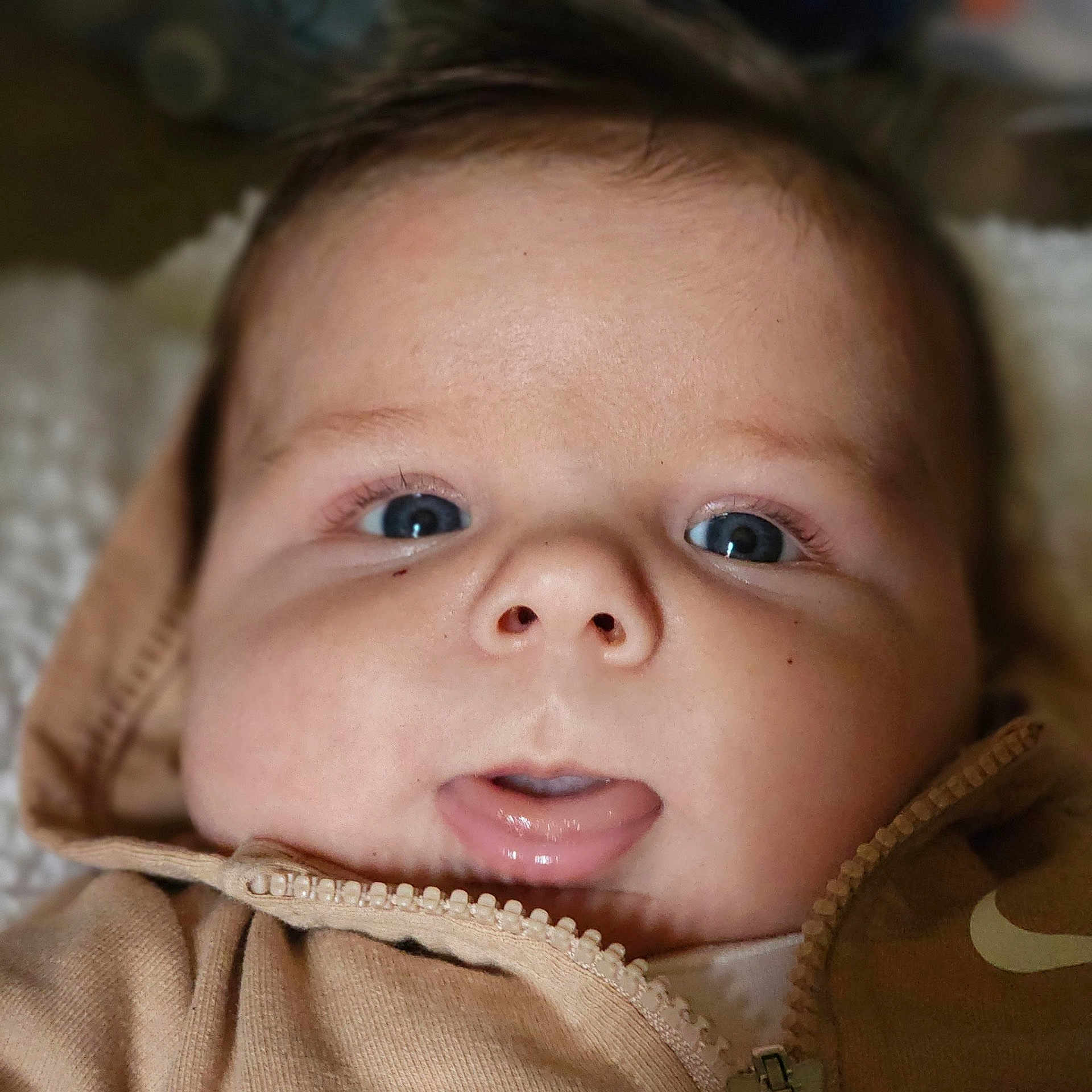 Octavyus joined the competition — help win amazing prizes! baby, closeup, face, blue_eyes, hoodie, zipper, infant, cute, expression, skin, mouth, tongue, clothing, portrait, child, young, soft_lighting, indoors, person, head