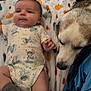 baby, dog, blanket, floor, onesie, socks, animal, pet, indoor, cute, infant, lying_down, companion, friendship, soft_texture, autumn, pattern, comfort, portrait, bond