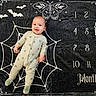 Jax is registered to the contest to win money with this photo: baby, infant, milestone_blanket, spiderweb, bat, butterfly, months, pajamas, smile, happy, child, portrait, lying_down, black_background, white_design, cute, young, floor, indoors, decor