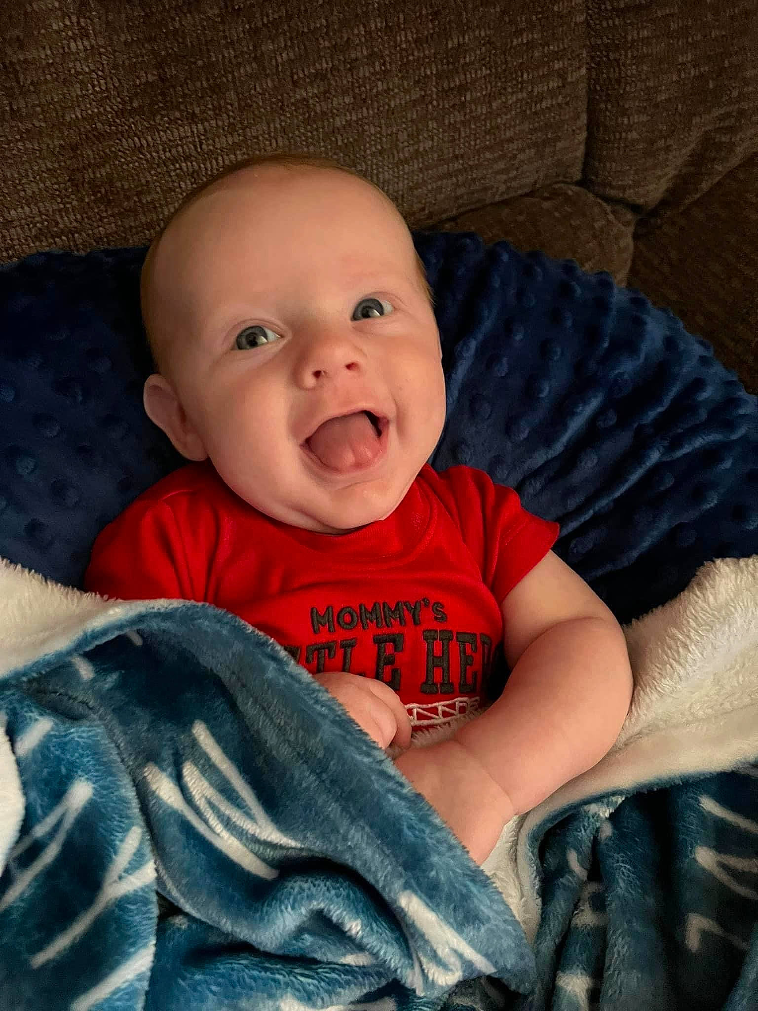 Marshall is registered to the contest to win money with this photo: baby, baby_toddler_clothing, cheek, child, comfort, couch, electric_blue, eye, flash_photography, happy, iris, leg, linens, mouth, nose, person, skin, sleeve, smile, t_shirt