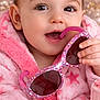 baby, toddler, child, portrait, pink_robe, sunglasses, toy_sunglasses, bow, hair_bow, cake, frosting, blanket, fuzzy_texture, closeup, rosy_cheeks, big_eyes, eyelashes, smiling, hand, indoor