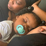 Myrical joined the competition — help win amazing prizes! adult, black_clothing, bonding, child, close_up, comfort, earrings, face, family, hair_buns, hand, indoor, intimacy, pacifier, portrait, relaxation, rest, skin, sleeping, white_shirt