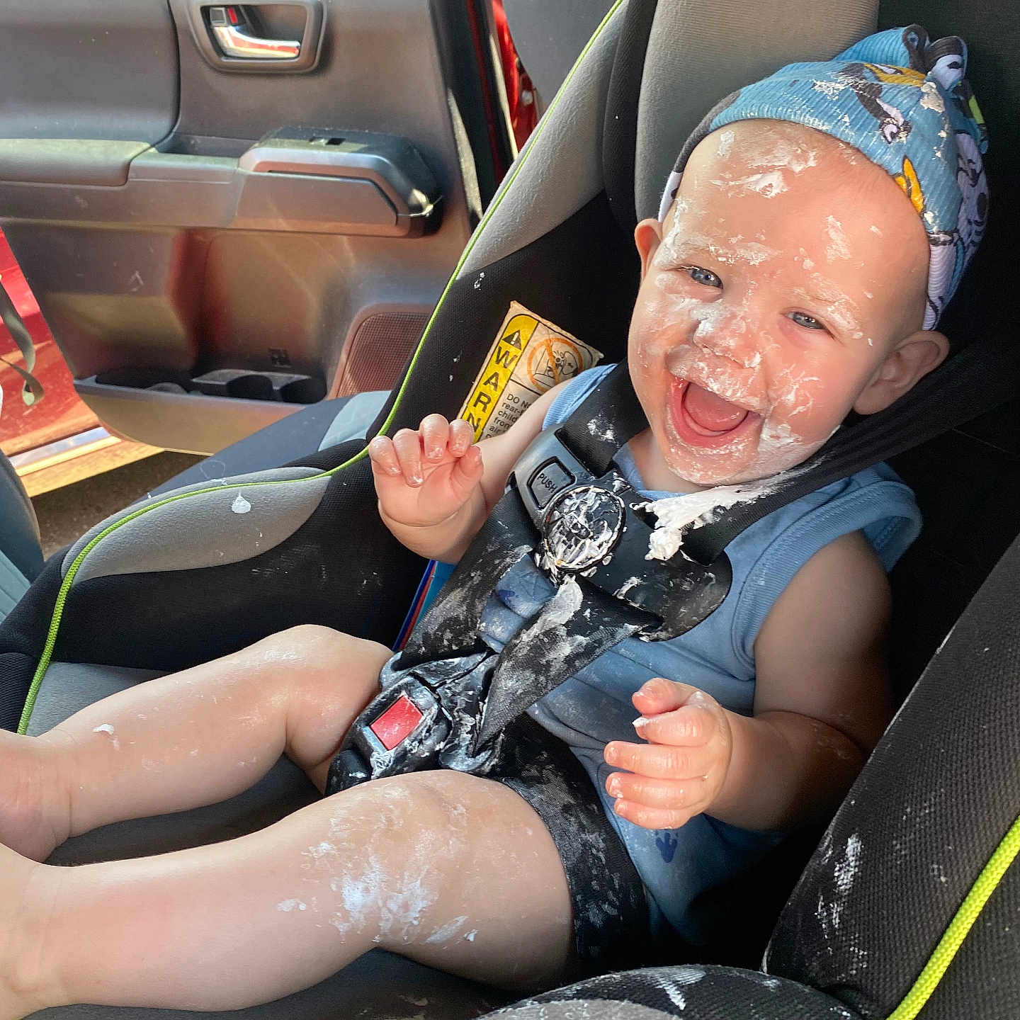 Arthur joined the competition — help win amazing prizes! baby, car_interior, car_seat, child, clothing, cream, cute, door, fun, happy, headband, infant, messy, playful, seatbelt, sitting, smiling, sunlight, vehicle, window
