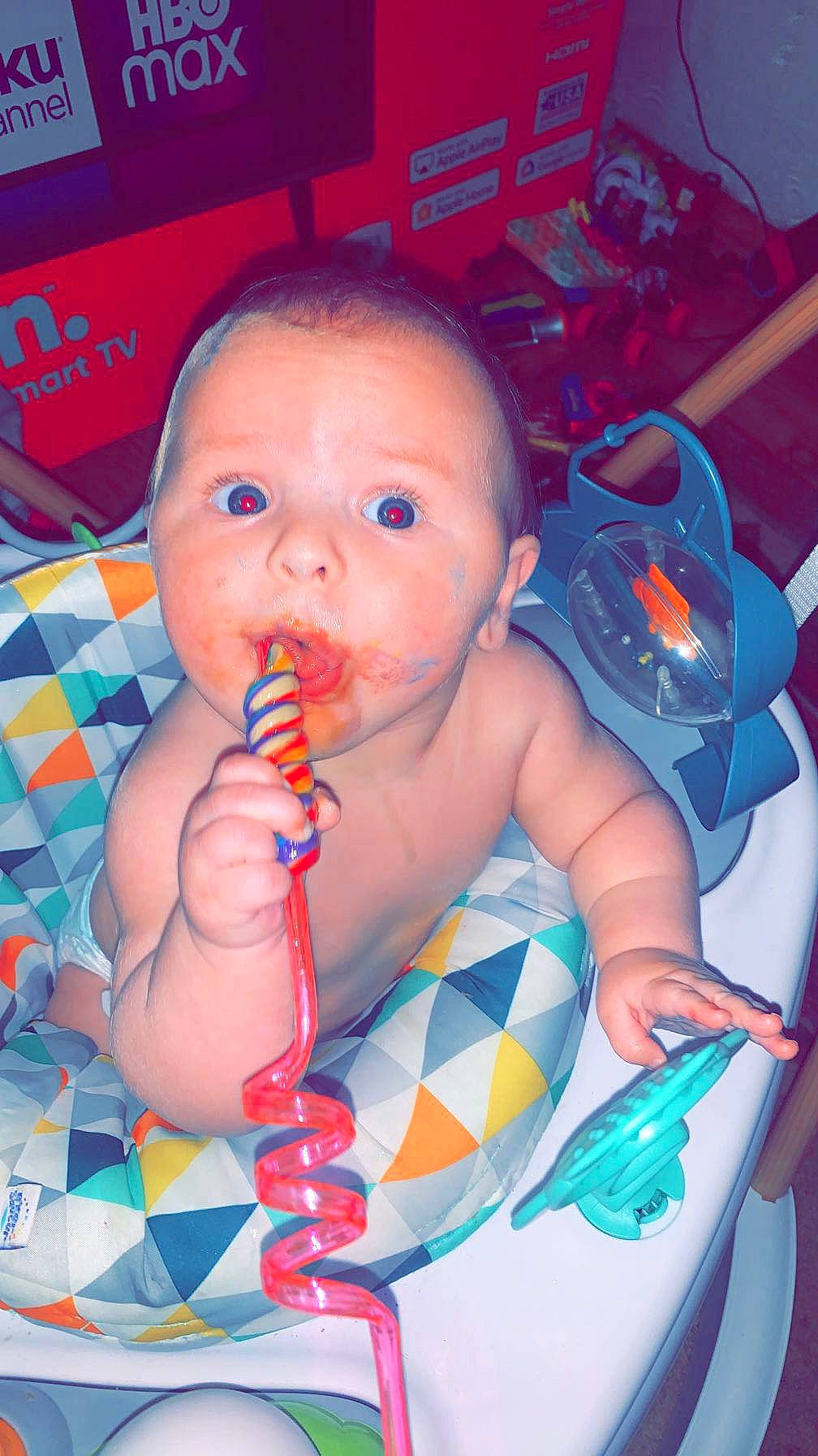 Brantley is registered to the contest to win money with this photo: arm, baby, baby_toddler_clothing, blue, cheek, child, facial_expression, finger, fun, human_body, iris, lip, mouth, nail, nose, orange, person, product, skin, thumb
