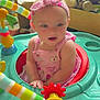 Rosina joined the competition — help win amazing prizes! baby, child, pink_dress, headband, activity_center, toy, indoor, playtime, colorful, cute, infant, seat, face, hands, expression, person, childhood, play, young, smiling