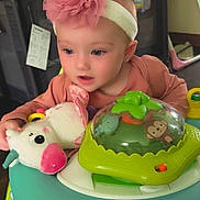 Rosina joined the competition — help win amazing prizes! baby, infant, headband, pink_flower, stuffed_toy, unicorn, baby_walker, toy, indoor, child, cute, playtime, face, person, clothing, seat, furniture, happy, curious, home