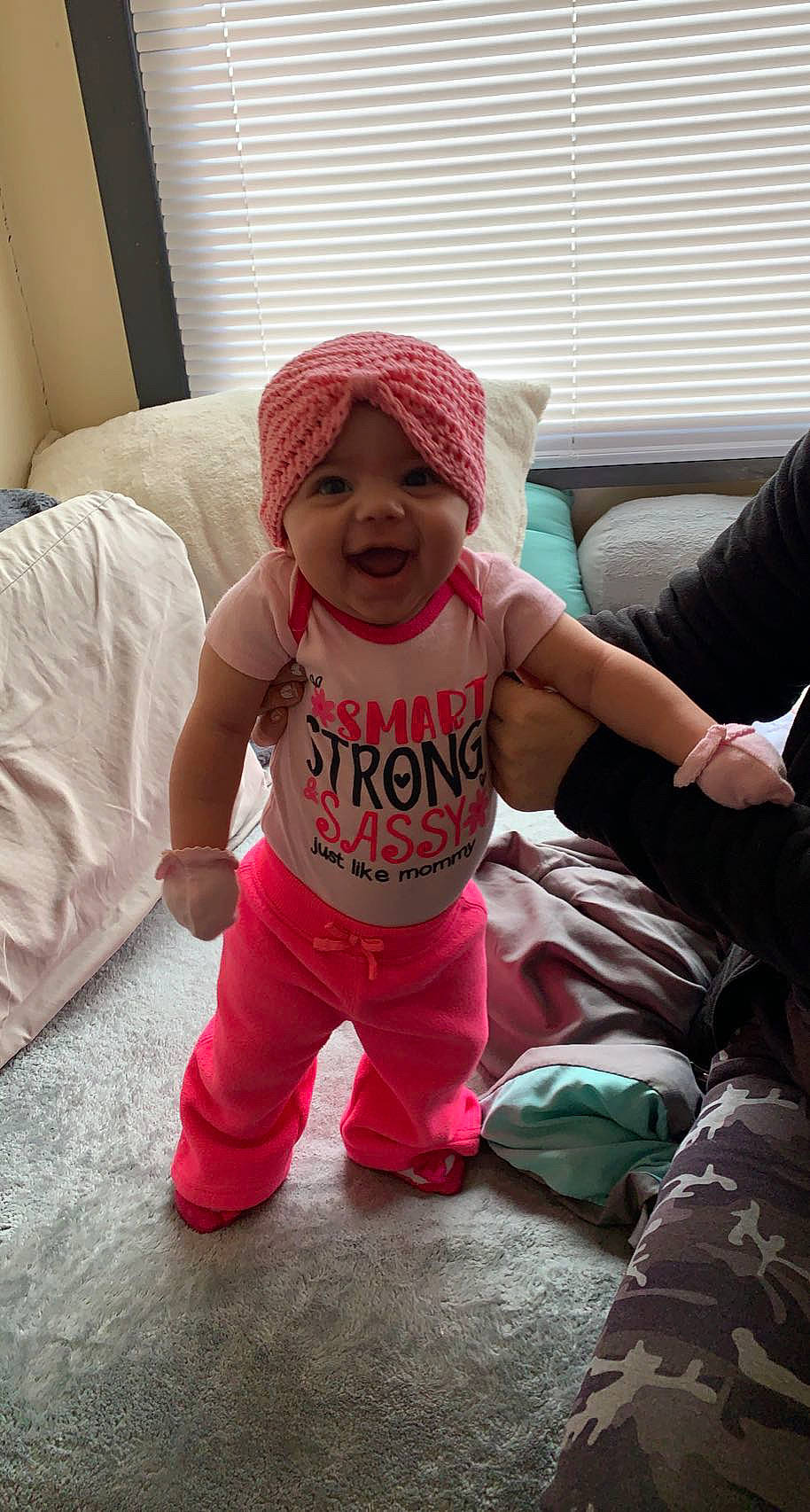 Thailynn is registered to the contest to win money with this photo: baby, baby_toddler_clothing, cap, child, comfort, cool, facial_expression, flooring, fun, happy, hat, headgear, headwear, magenta, person, pink, sitting, sleeve, smile, t_shirt