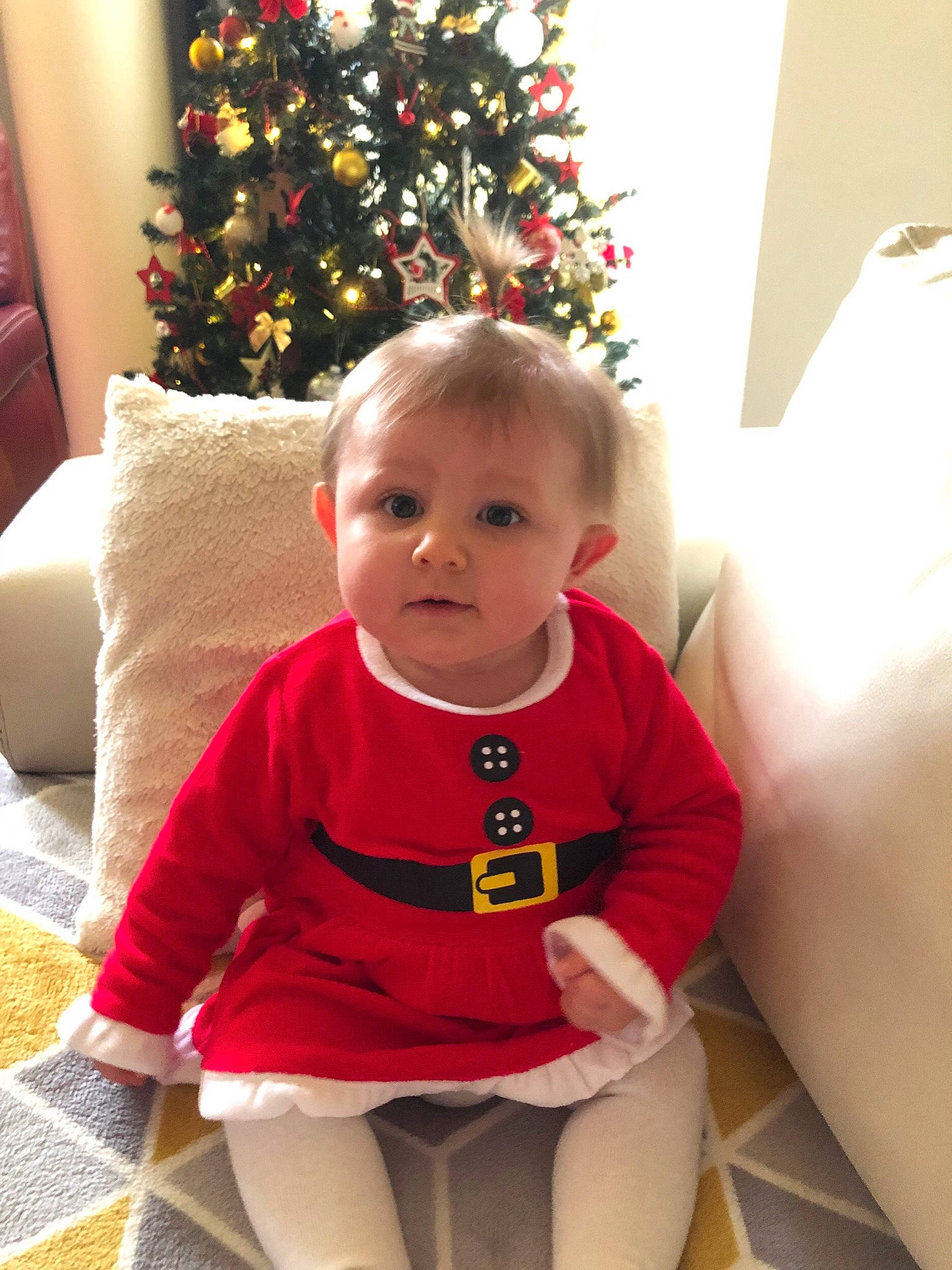 Mya participe au concours pour gagner de l'argent avec cette photo : baby_toddler_clothing, christmas, christmas_decoration, christmas_eve, christmas_ornament, christmas_tree, comfort, holiday, holiday_ornament, home, home_accessories, human_body, interior_design, living_room, ornament, person, room, sitting, sock, toddler