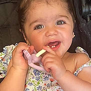 Aleyna is registered to the contest to win money with this photo: baby, child, female, teething_toy, stroller, floral_dress, smiling, happy, cute, infant, hair_tie, portrait, young_child, chewing, seatbelt, closeup, indoors, person, skin, hand