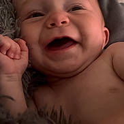 Weldyn is registered to the contest to win money with this photo: baby, child, smiling, laughing, close_up, face, skin, blanket, furry, pillow, happy, infant, cute, lying_down, expression, portrait, indoors, small_hand, body, young