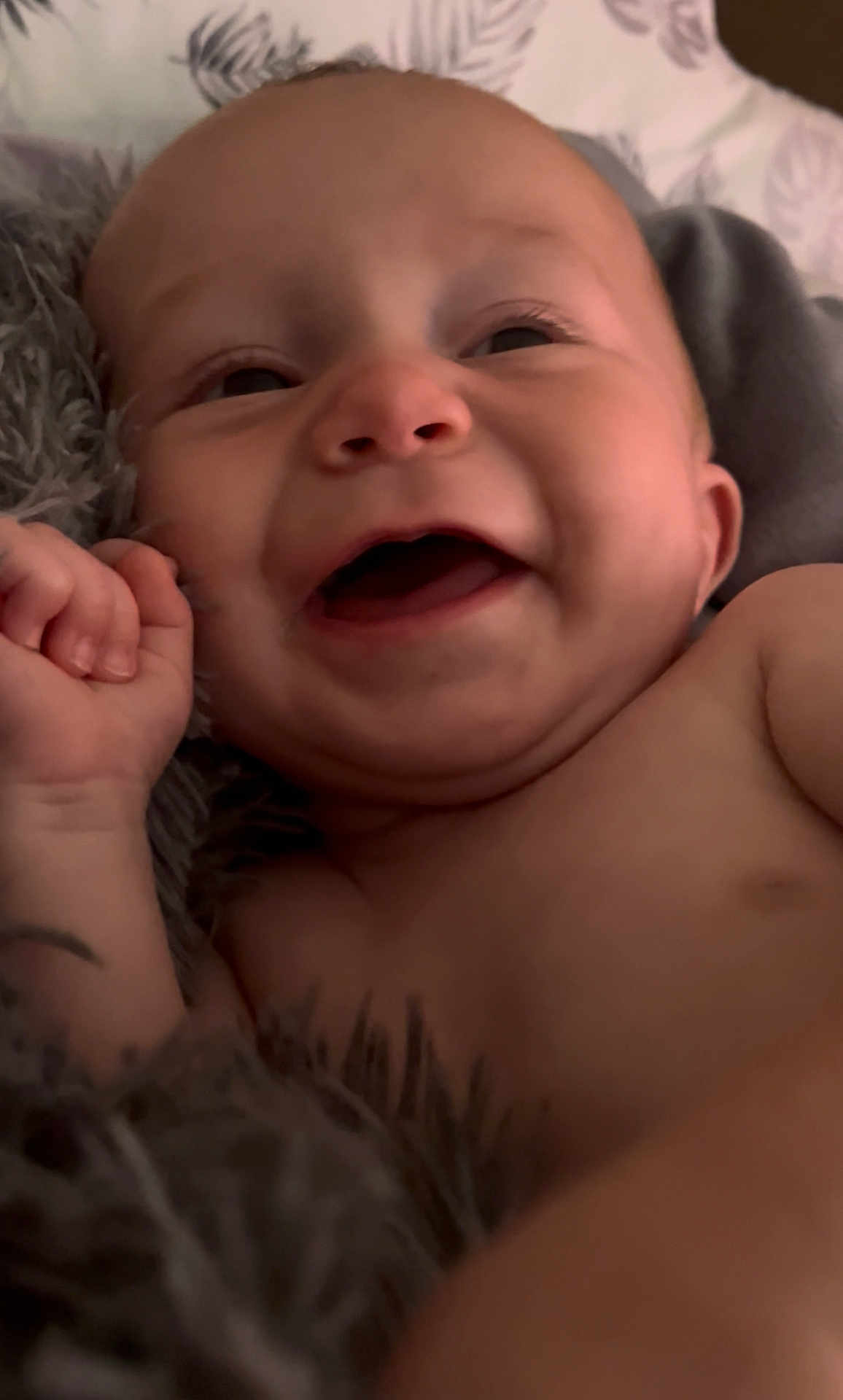 Weldyn is registered to the contest to win money with this photo: baby, child, smiling, laughing, close_up, face, skin, blanket, furry, pillow, happy, infant, cute, lying_down, expression, portrait, indoors, small_hand, body, young