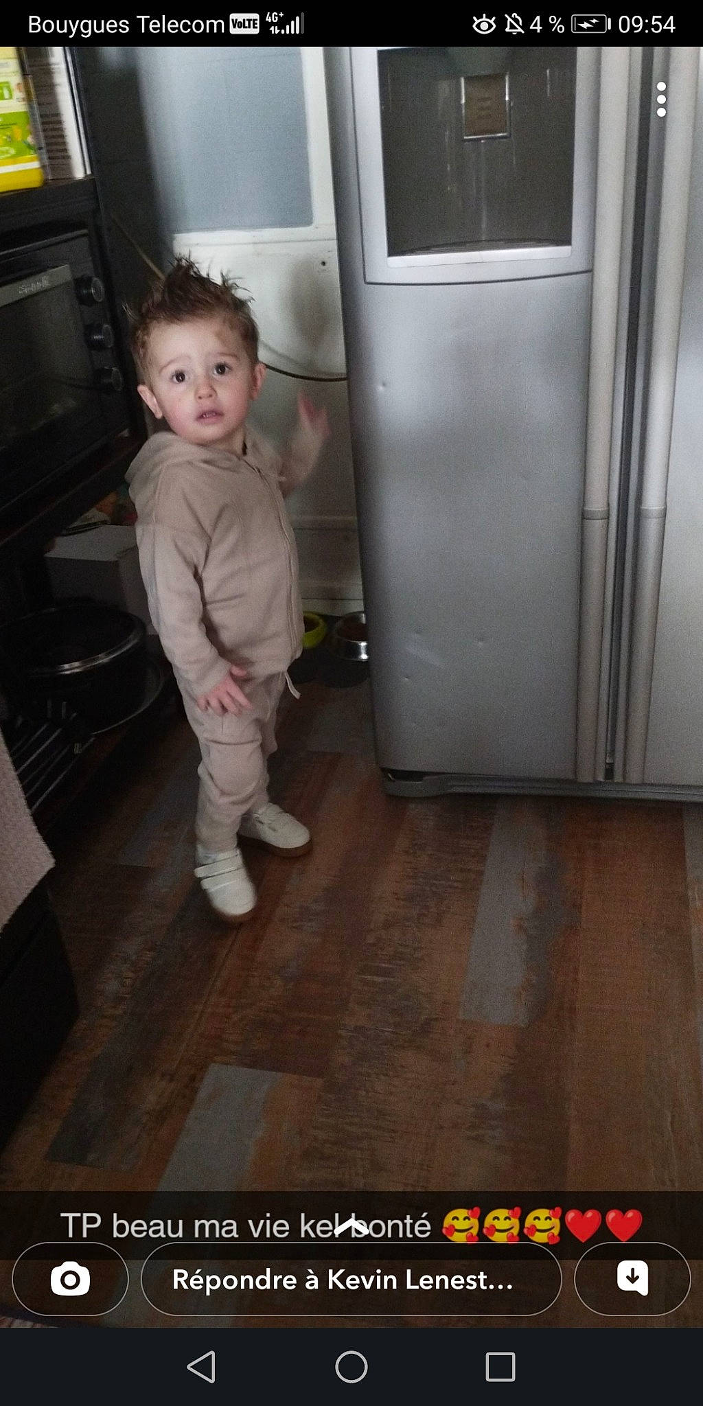 Mason participe au concours pour gagner de l'argent avec cette photo : cabinetry, child, door, floor, flooring, foot, fun, gas, hardwood, home_appliance, human_leg, kitchen_appliance, machine, major_appliance, person, refrigerator, room, surprise, television, toddler