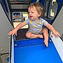 Ozzee is registered to the contest to win money with this photo: toddler, child, playground, slide, blue, onesie, sun_pattern, happy, smiling, outdoor, play, fun, baby, clothing, feet, hands, metal, plastic, daytime, park