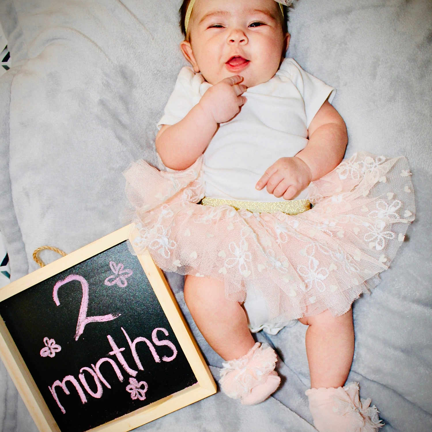 Reina is registered to the contest to win money with this photo: baby, bed, birthdaycake, blackboard, bodypart, cake, clothing, cream, dress, face, finger, furniture, hand, hat, head, indoors, newborn, person, photography, portrait