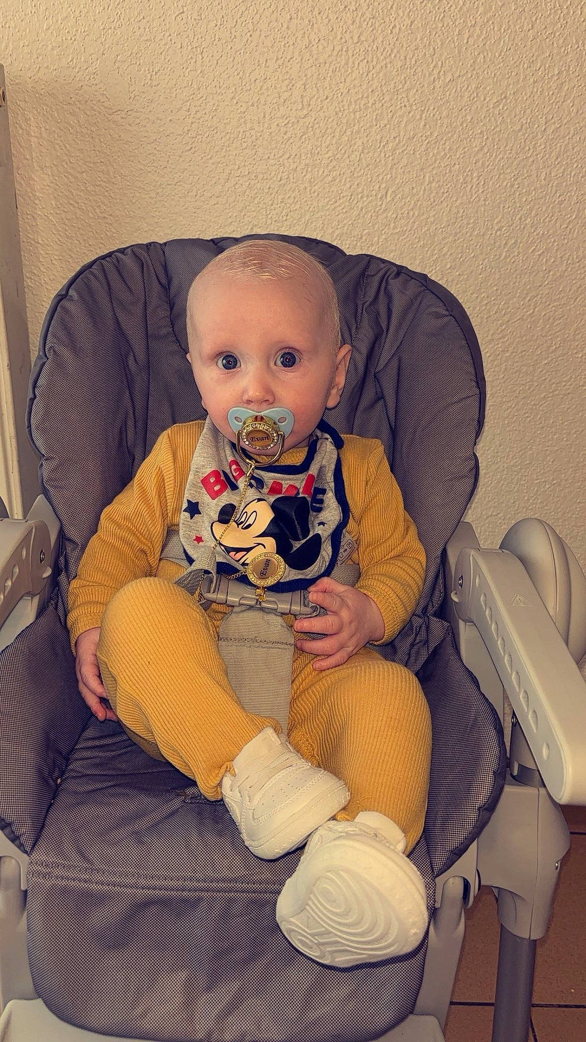 Evan participe au concours pour gagner de l'argent avec cette photo : arm, baby, baby_toddler_clothing, chair, child, comfort, finger, hairstyle, human_body, human_leg, knee, lap, leg, mouth, person, product, shoe, skin, sneakers, surprise