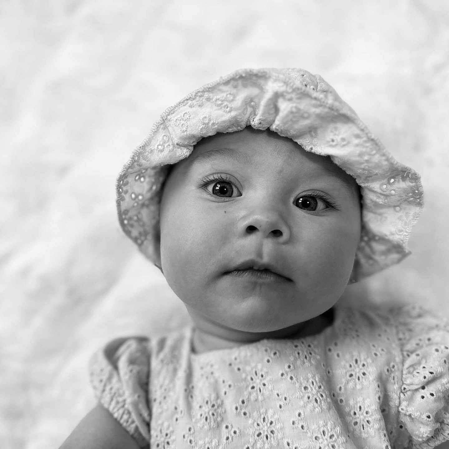 Valentina Laurent participe au concours pour gagner de l'argent avec cette photo : baby, background, black_and_white, child, closeup, clothing, cute, expression, eyes, fabric, face, hat, headwear, infant, innocence, portrait, sleeves, soft_light, texture, young_child