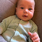 Jaxson is registered to the contest to win money with this photo: baby, infant, child, face, eyes, hand, clothing, onesie, green, cute, portrait, indoor, soft_light, fabric, chair, young, skin, expression, curious, toddler