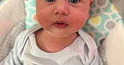 Jaxson is registered to the contest to win money with this photo: baby, child, infant, face, eyes, onesie, seat, patterned, comfort, curious, closeup, rosy_cheeks, soft, looking, expression, indoor, portrait, cute, young, person
