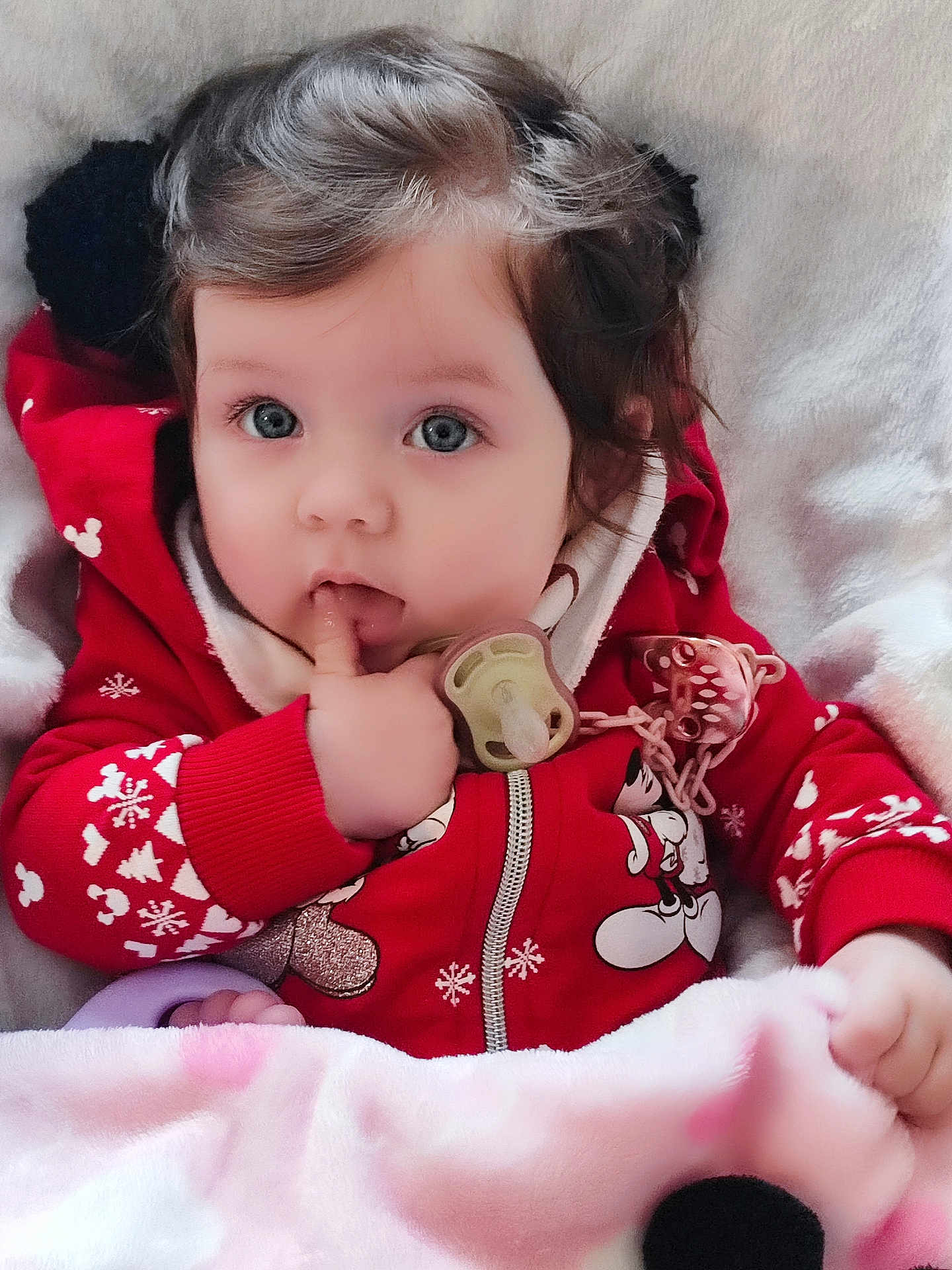Valentina participe au concours pour gagner de l'argent avec cette photo : baby, child, infant, cute, curly_hair, red_jacket, mickey_mouse, pacifier, blanket, indoors, portrait, hand, finger_in_mouth, cozy, winter_clothing, soft_texture, closeup, adorable, face, blue_eyes