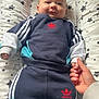 Elïo participe au concours pour gagner de l'argent avec cette photo : adidas, apparel, baby, baby_calin, child, clothing, comfort, cushion, cute, face, hand_holding, indoor, infant, lying_down, parental_touch, person, smiling, sock, sportswear, stars_pattern