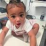 toddler, child, baby, face, hair_bow, bathroom, counter, candle, jar, jumbo_olives, hair_straightener, white_shirt, striped_overall, socks, curious, indoor, person, closeup, exploring, cute