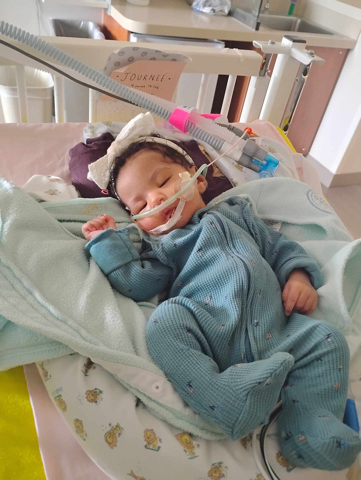 Journe'E joined the competition — help win amazing prizes! baby, infant, sleeping, hospital, crib, medical_tubes, blanket, blue_onesie, headband, bow, monitor, healthcare, child, pediatric, cute, cozy, bed, soft_toys, nursery, resting
