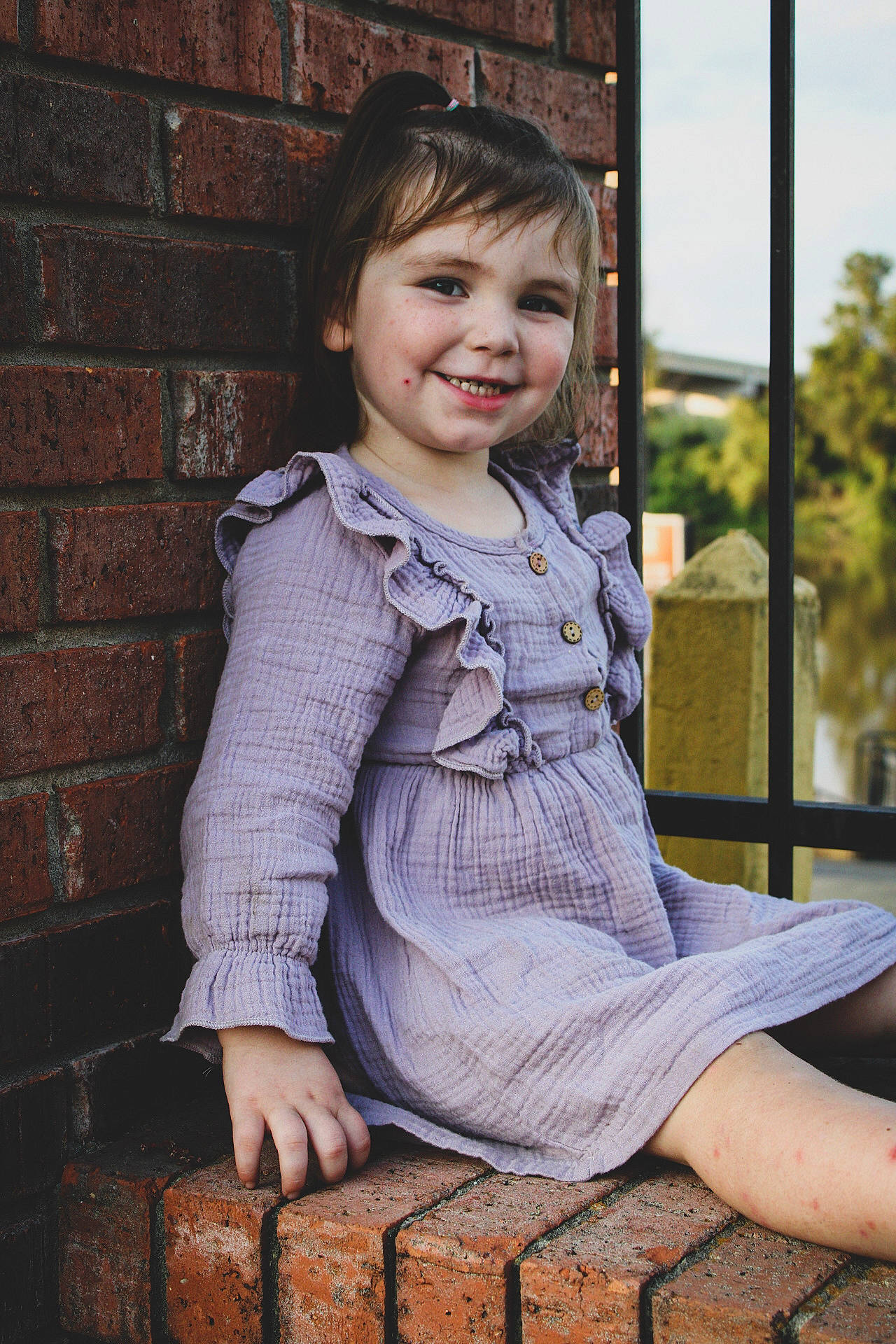 Annaliese is registered to the contest to win money with this photo: baby_toddler_clothing, bangs, brick, brickwork, building_material, button, child_model, clothing, day_dress, dress, embellishment, flash_photography, happy, joy, laugh, nose, person, photo_shoot, portrait, portrait_photography