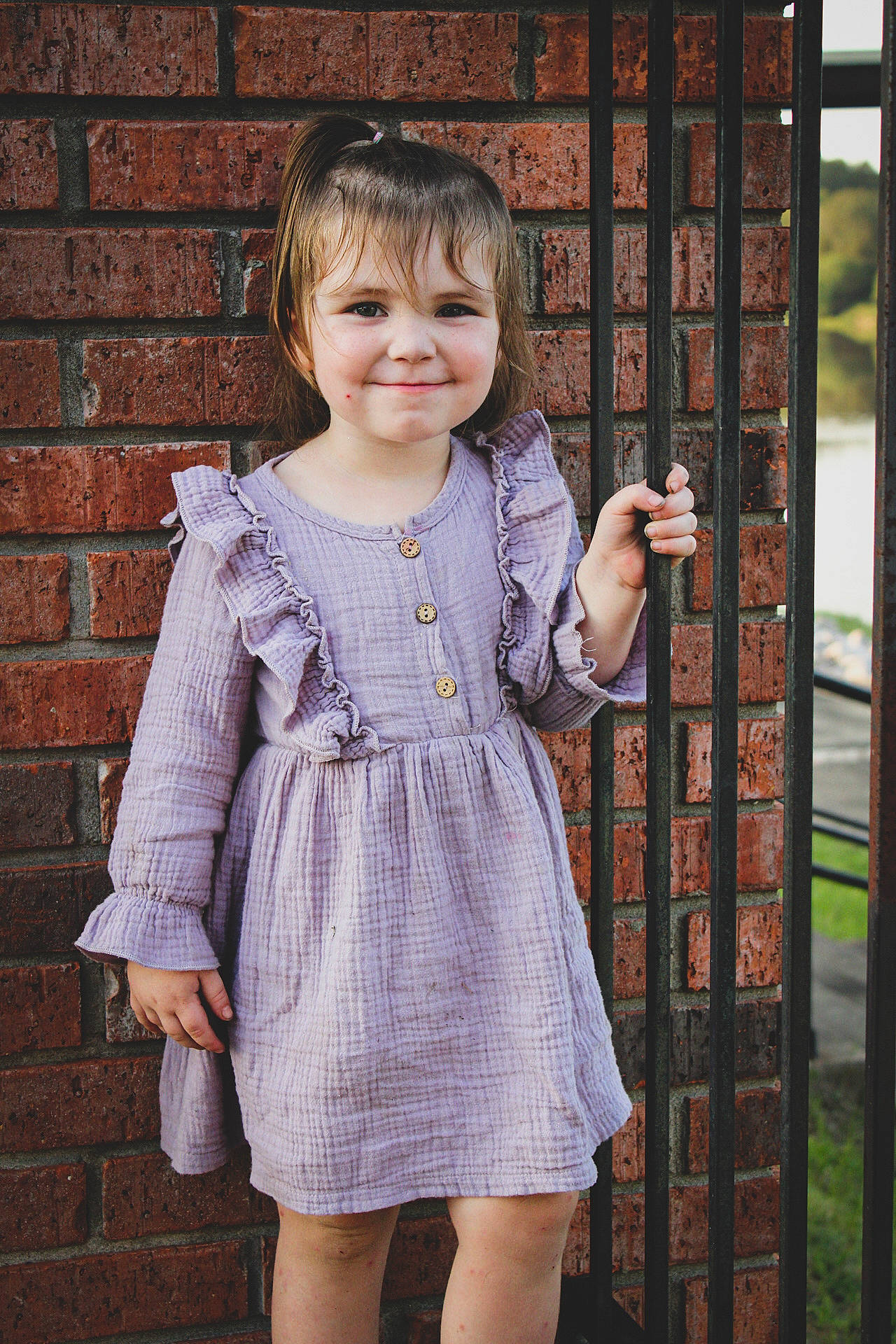 Annaliese is registered to the contest to win money with this photo: baby_toddler_clothing, bangs, brick, brickwork, button, child_model, clothing, day_dress, dress, embellishment, iris, joy, one_piece_garment, pattern, person, sleeve, toddler