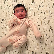 Trinity is registered to the contest to win money with this photo: baby, infant, onesie, blanket, patterned_blanket, lying_down, cute, smiling, face, child, indoor, soft_lighting, sleepwear, newborn, young_child, expression, human, portrait, baby_girl, baby_boy