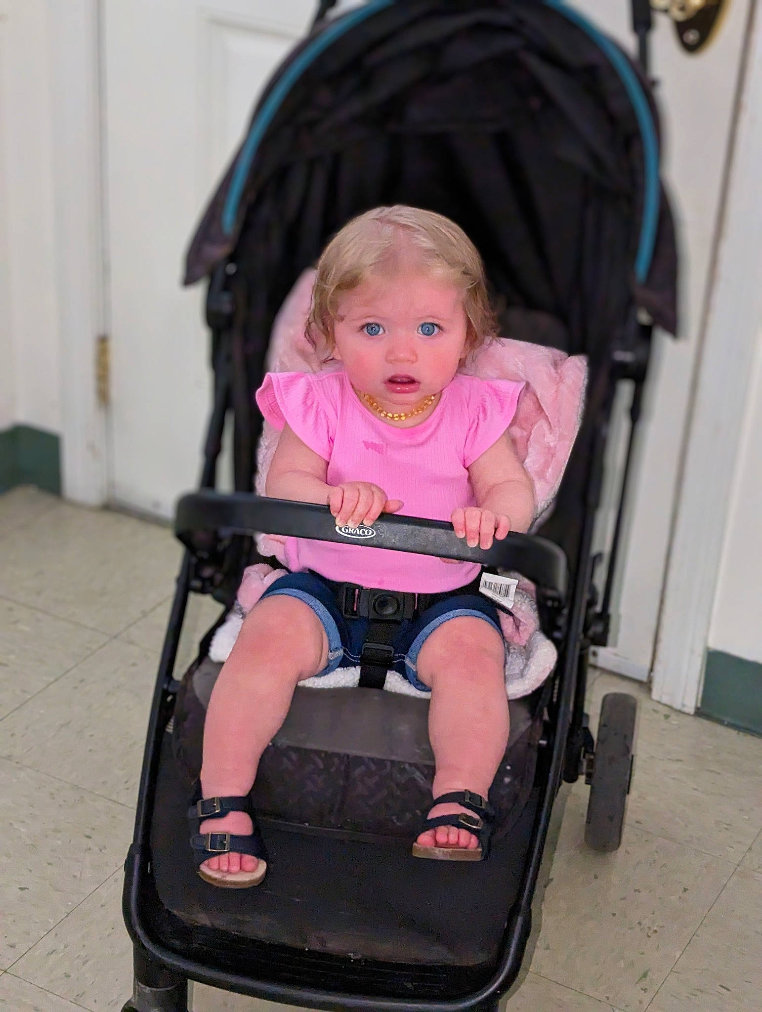 Aviana is registered to the contest to win money with this photo: arm, baby, baby_carriage, baby_products, baby_toddler_clothing, chair, child, comfort, eye, fun, head, human_body, lap, magenta, person, pink, product, sitting, tire, toddler
