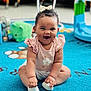 Everlie is registered to the contest to win money with this photo: baby, child, smiling, sitting, indoor, playroom, toy, carpet, cute, bow, clothing, happy, infant, person, toddler, footwear, colorful, floor, young_child, play