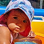 Divya a rejoint le concours — aidez-le/la à gagner de superbes lots ! toddler, child, hat, swimming_pool, water, sunhat, outdoor, summer, face, skin, curious, bright_colors, inflatable, blue, yellow, pink, closeup, baby, sunlight, play