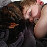 arm, bedding, blanket, cat, child, close_up, cozy, cuddle, eyelashes, face, hair, indoor, nap, pacifier, pet, sleeping, snuggling, soft_texture, tortoiseshell_cat, whiskers