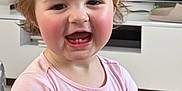 Allison is registered to the contest to win money with this photo: toddler, child, smiling, happy, pink_shirt, hair_clip, indoor, living_room, television, cabinet, keychain, short_sleeves, cute, rosy_cheeks, person, portrait, young_child, baby, expression, hand