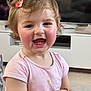 toddler, child, smiling, happy, pink_shirt, hair_clip, indoor, living_room, television, cabinet, keychain, short_sleeves, cute, rosy_cheeks, person, portrait, young_child, baby, expression, hand