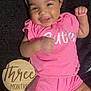 baby, infant, smile, pink_clothing, headband, bow, cute, happy, lying_down, milestone, wooden_plaque, three_months, fingers, cheeks, black_blanket, cute_expression, portrait, child, young_baby, celebration